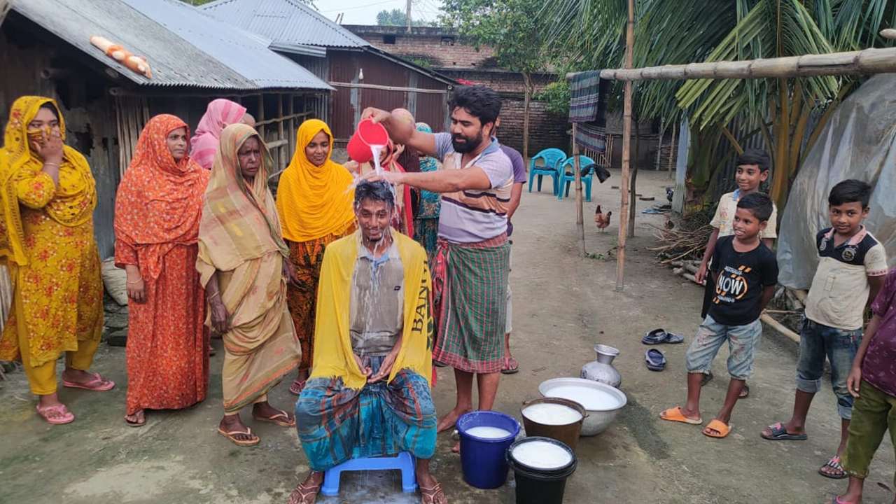 দুধ দিয়ে গোসল করছেন সবুজ মিয়া। ছবি : কালবেলা