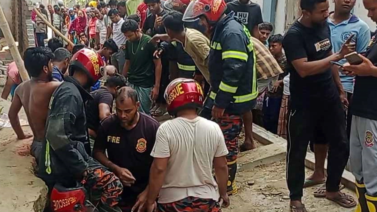 চাপা পড়া দেয়ালের নিচ থেকে শ্রমিকদের উদ্ধার করে ফায়ার সার্ভিসের কর্মীরা। ছবি : কালবেলা