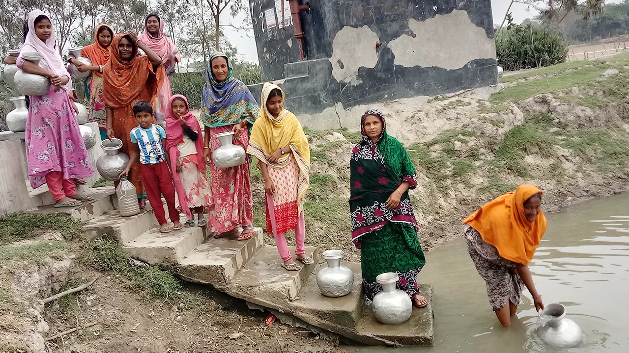 পুকুর থেকে পানি নিচ্ছেন এলাকার নারী শিশুরা। ছবি : কালবেলা